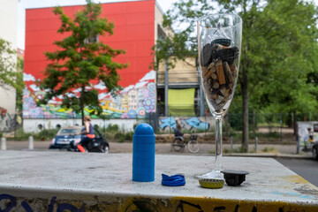 Fototapeta na wymiar Überrest einer nächtichen Party in Berlin-Prenzlauer Berg - Ein Sektglas voller Zigarettenstummel