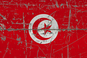 Obraz premium Tunisia flag painted on cracked dirty surface. National pattern on vintage style surface. Scratched and weathered concept.