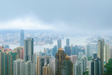 Fototapeta na wymiar Monsoon fog descending on Hong Kong central district, with high rise business and residential buidlings along the river, from Victoria Peak in Hong Kong, China
