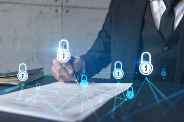 Businessman in suit signs contract. Double exposure with lock icon hologram. Man signing agreement...