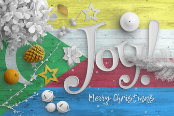 Comoros flag on wooden table with joy text. Christmas and new year background, celebration national...
