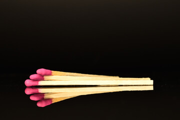 Matches made of wood, close-up, on a black background.