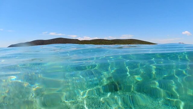 Underwater split video of beautiful exotic emerald sandy bay in summertime 
