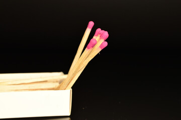 Matches made of wood, close-up, on a black background.