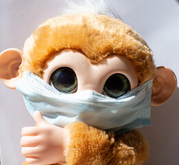 Toy monkey wearing a surgery mask as a virus protection teach for kids