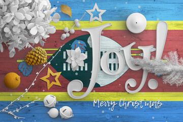 Swaziland flag on wooden table with joy text. Christmas and new year background, celebration...