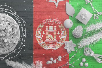 Afghanistan flag on wooden table with snow objects. Christmas and new year background, celebration...
