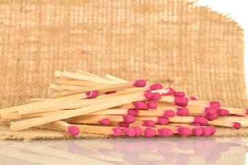 Matches made of wood, close-up, on jute fabric.