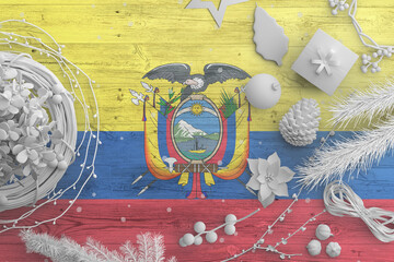 Ecuador flag on wooden table with snow objects. Christmas and new year background, celebration national concept with white decor.
