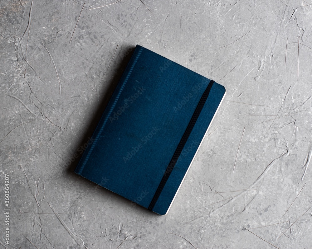 Poster overhead shot of a notebook on a gray background