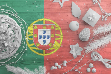 Portugal flag on wooden table with snow objects. Christmas and new year background, celebration national concept with white decor.