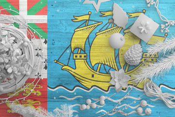 Naklejka premium Saint Pierre And Miquelon flag on wooden table with snow objects. Christmas and new year background, celebration national concept with white decor.