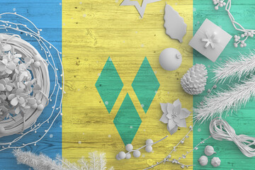 Saint Vincent And The Grenadines flag on wooden table with snow objects. Christmas and new year...