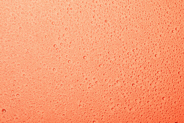 pink background with drops of liquid on the surface