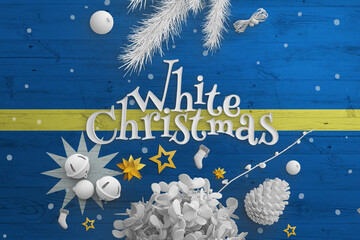 Nauru flag on wooden table with White Christmas text. Christmas and new year background,...