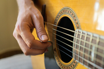 Fototapeta premium A man's hand playing an acoustic guitar.