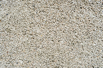 Close-up of texture of small stones or gravel. Concrete surface with copy space. Construction and building concept. Fine gravel road surface. Paving of small pebbles.