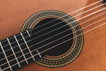 Vintage style photo of a classical guitar. Strings, sound hole, rosette and finger board.