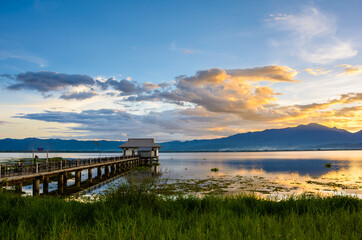 Lake house in lake at sunset with dramatic sunset sky.