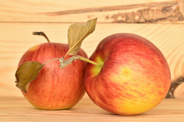 Ripe red apples, close-up, on a background of natural wood.
