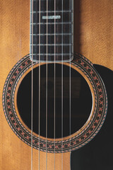 Close up photo of the strings and sound hole of a classical guitar