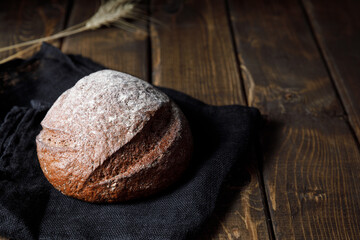 Loaf of rye bread on wooden table background