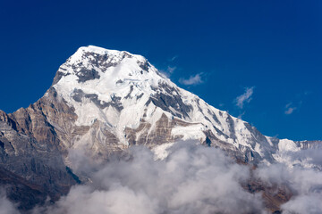 Annapurna South mountain peak with blue sky background in Nepal