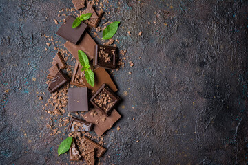 Pieces of tasty milk and dark chocolate with fresh mint leaves