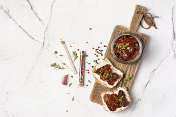 Bright sandwich with tasty spicy sun dried tomatoes with thyme, pepper and salt in glass jar