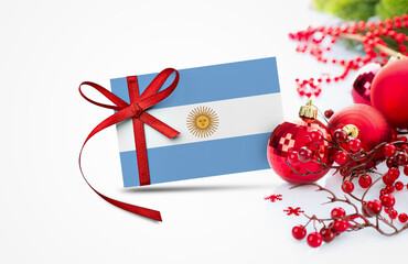 Argentina flag on new year invitation card with red christmas ornaments concept. National happy new year composition.