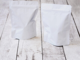 Empty white zip package for food on vintage wooden table.