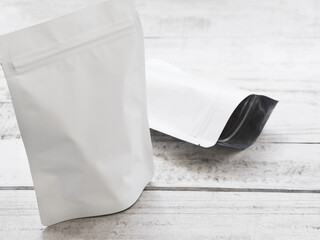 Empty white zip package for food on vintage wooden table.