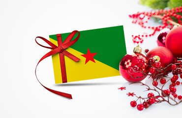 French Guiana flag on new year invitation card with red christmas ornaments concept. National happy new year composition.