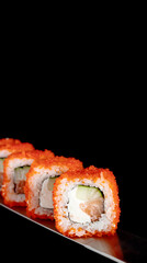 Japanese rolls and seafood sushi on a katana sword on a black background