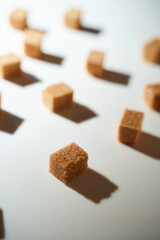 Cubes of cane sugar on a white background with a shadow. Top view.