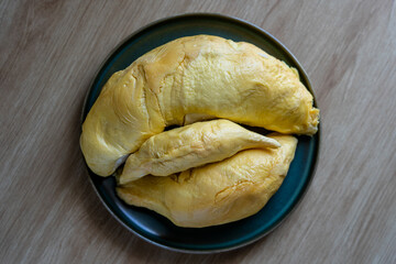 Top view on the fresh durian fruit placed on a plate. Durian the king of fruits. Ripe tropical durian fruit in summer for a sweet dessert or snack in Asia