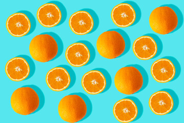 Orange oranges and cut oranges on turquoise background. Image of fresh oranges for the summer.