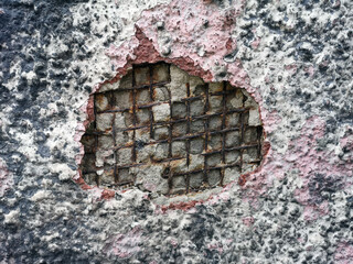 Background, texture. Iron rusted fittings in a breakaway concrete wall and plaster. The iron lattice