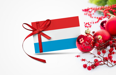 Luxembourg flag on new year invitation card with red christmas ornaments concept. National happy new year composition.