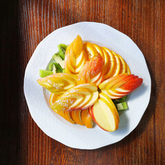beautifully sliced fruit on a white plate, top view