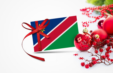 Namibia flag on new year invitation card with red christmas ornaments concept. National happy new year composition.