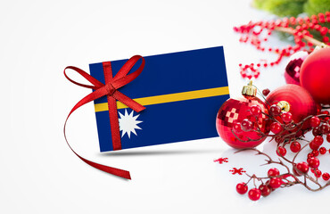 Nauru flag on new year invitation card with red christmas ornaments concept. National happy new...