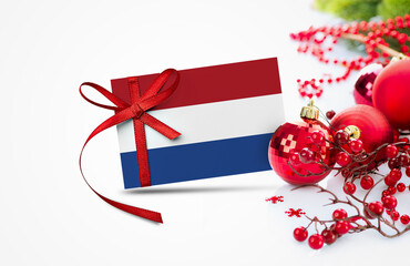 Netherlands flag on new year invitation card with red christmas ornaments concept. National happy new year composition.