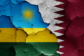 flags of Rwanda and Qatar painted on cracked wall