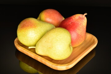 Naklejka na ściany i meble Sweet ripe pears, close-up, on a black background.