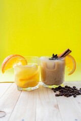 summer drinks. tropical summer concept. lemonade and coffee-orange cocktail with cinnamon on a yellow background