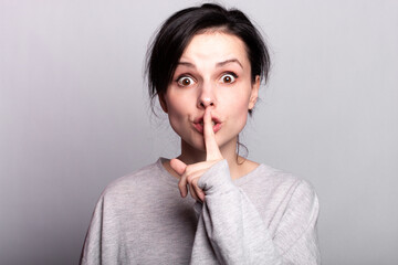 emotion woman in a gray t-shirt on a gray background