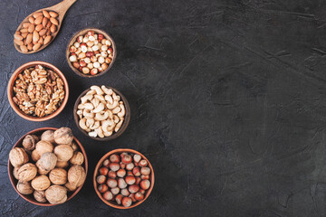 Different nuts in dishes, walnuts, hazelnuts, cashews and almonds