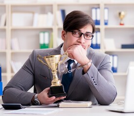 Businessman with golden cup in the office