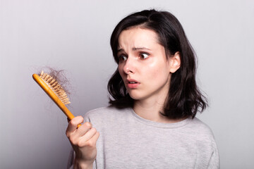 Beautiful woman comb hair grey shirt fall out